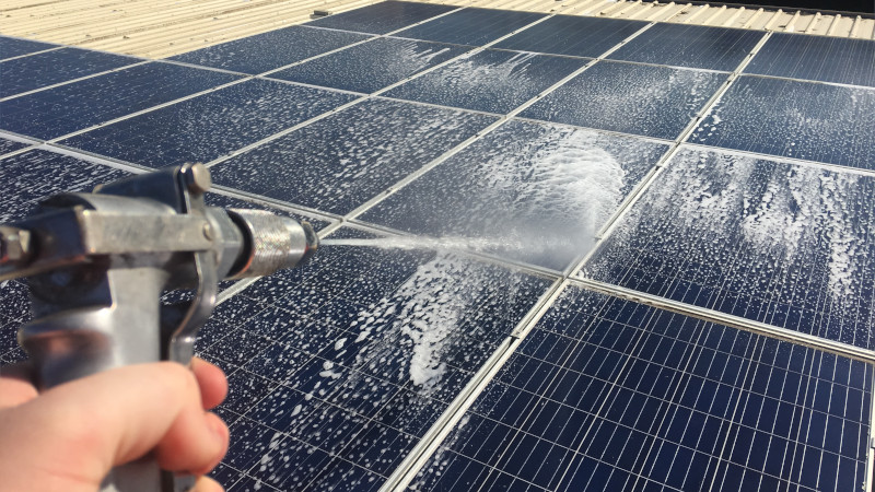 Applying moss treatment to solar panels using a sprayer