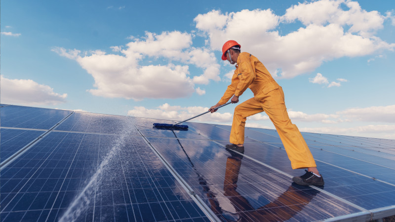 Manual cleaning of solar panels using a broom