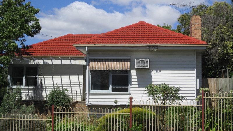 Red painted roof after moss treatment showing a clean surface