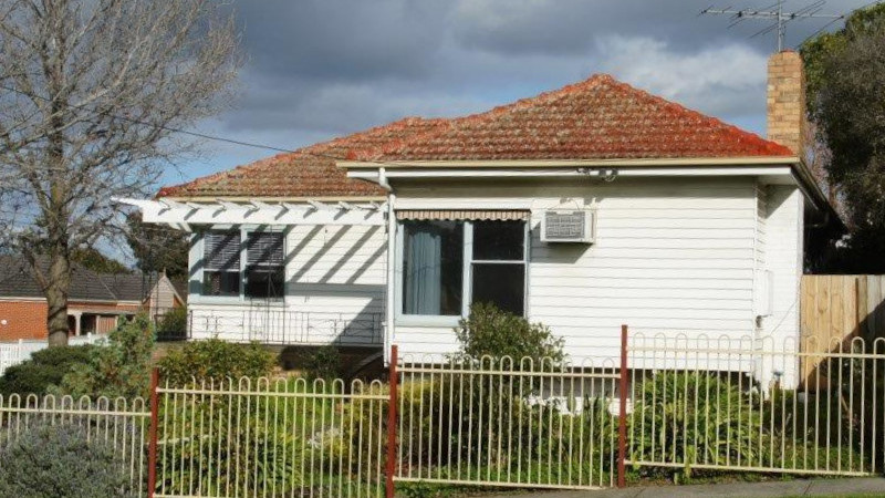 Red painted roof before moss treatment showing moss growth